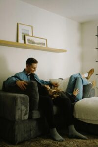 A couple relaxing on a couch, enjoying a quiet moment in a minimalist living room.
